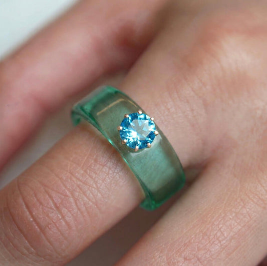 Anillo CG de topacio Swiss Blue y resina menta, puesto en la mano
