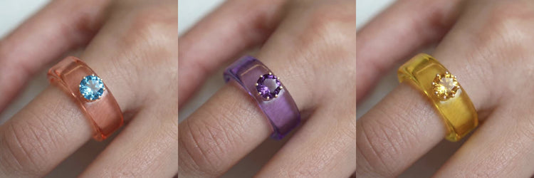 Anillos CG puestos en mano, en salmón, morado y amarillo