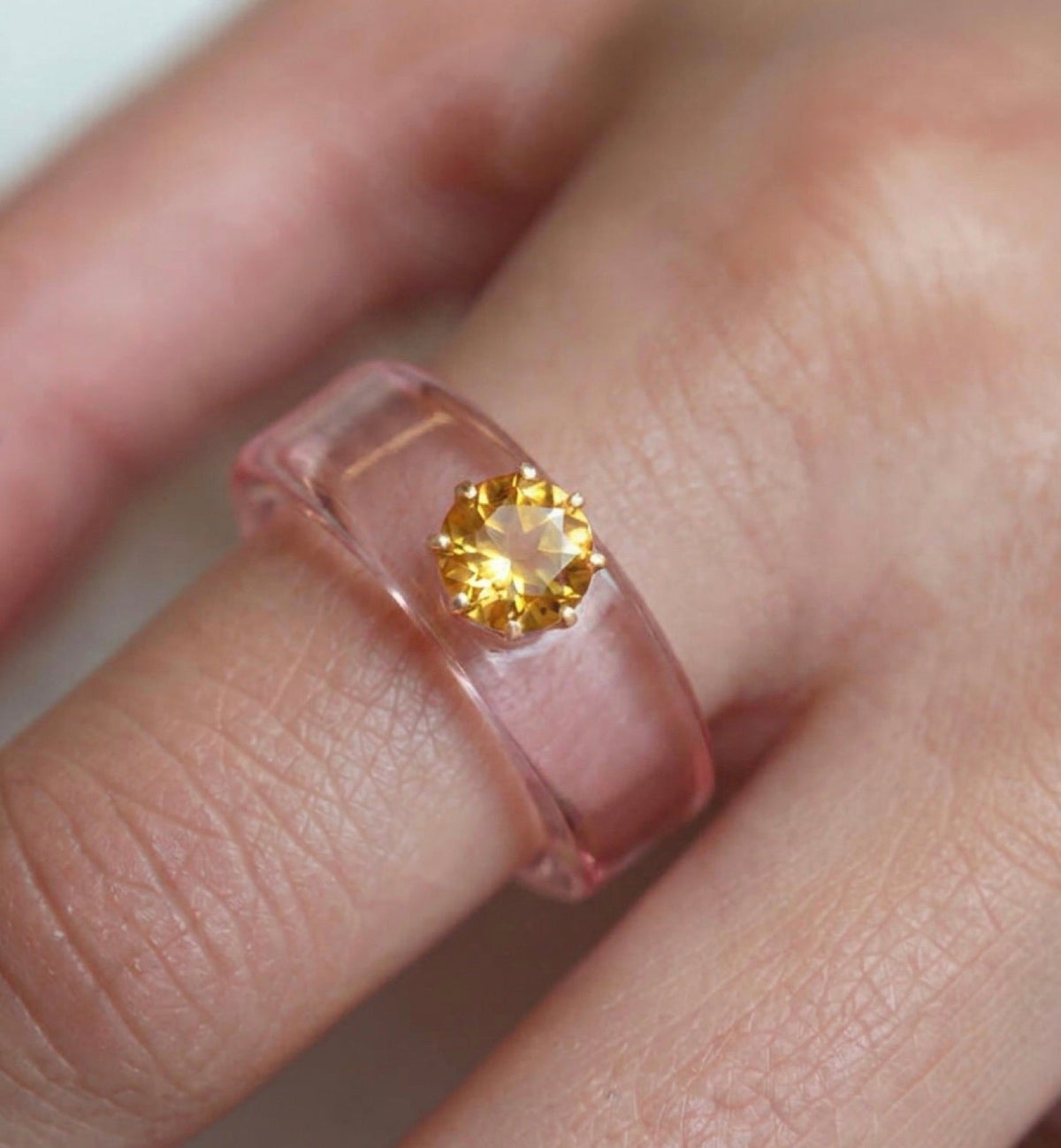 Anillo CG de citrino y resina rosa, puesto en la mano