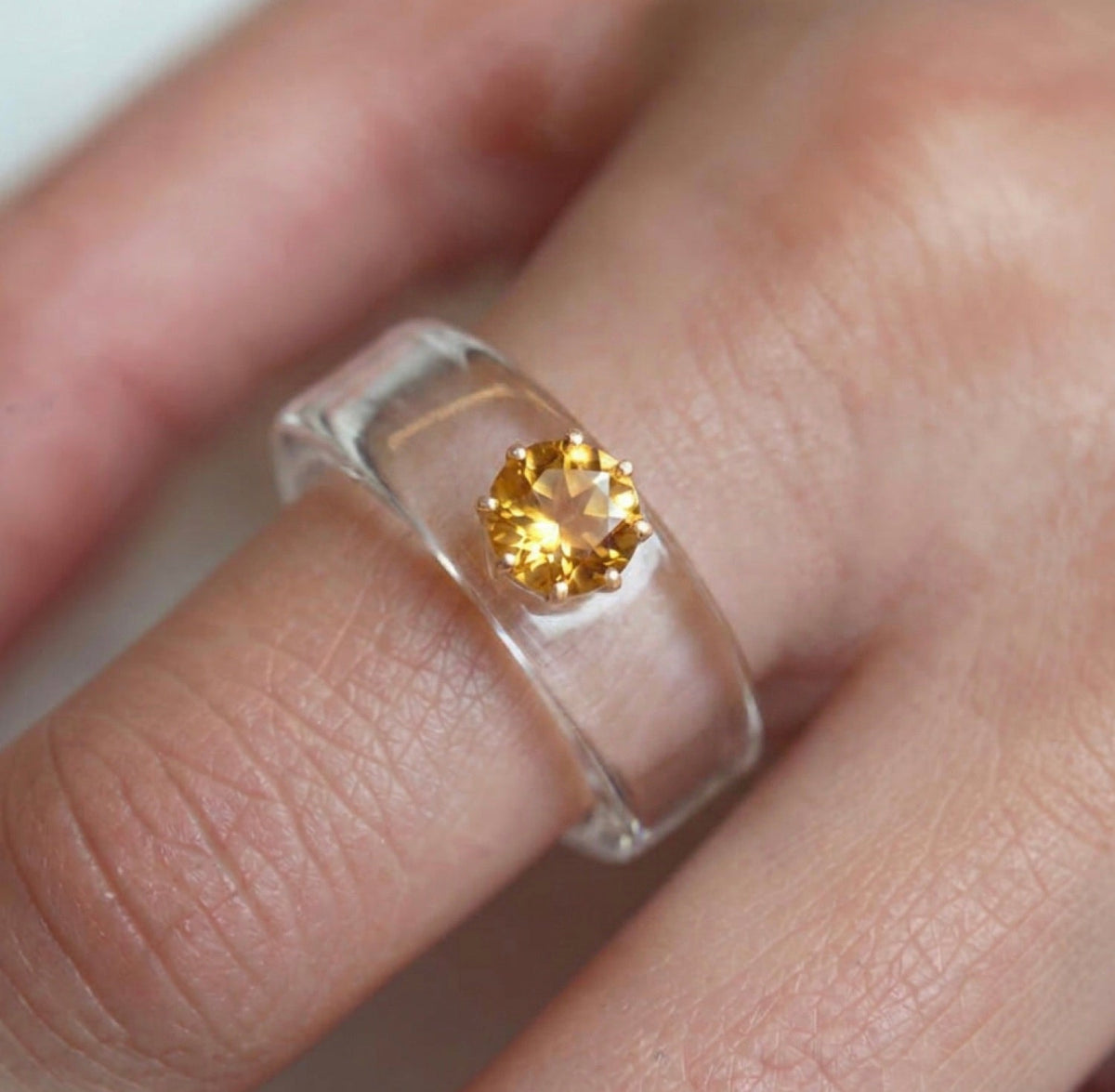 Anillo CG de citrino y resina transparente, puesto en la mano