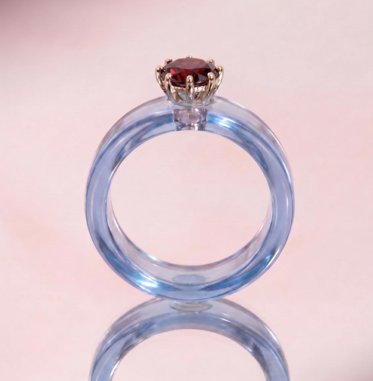 Anillo CG de granate y resina celeste, de frente