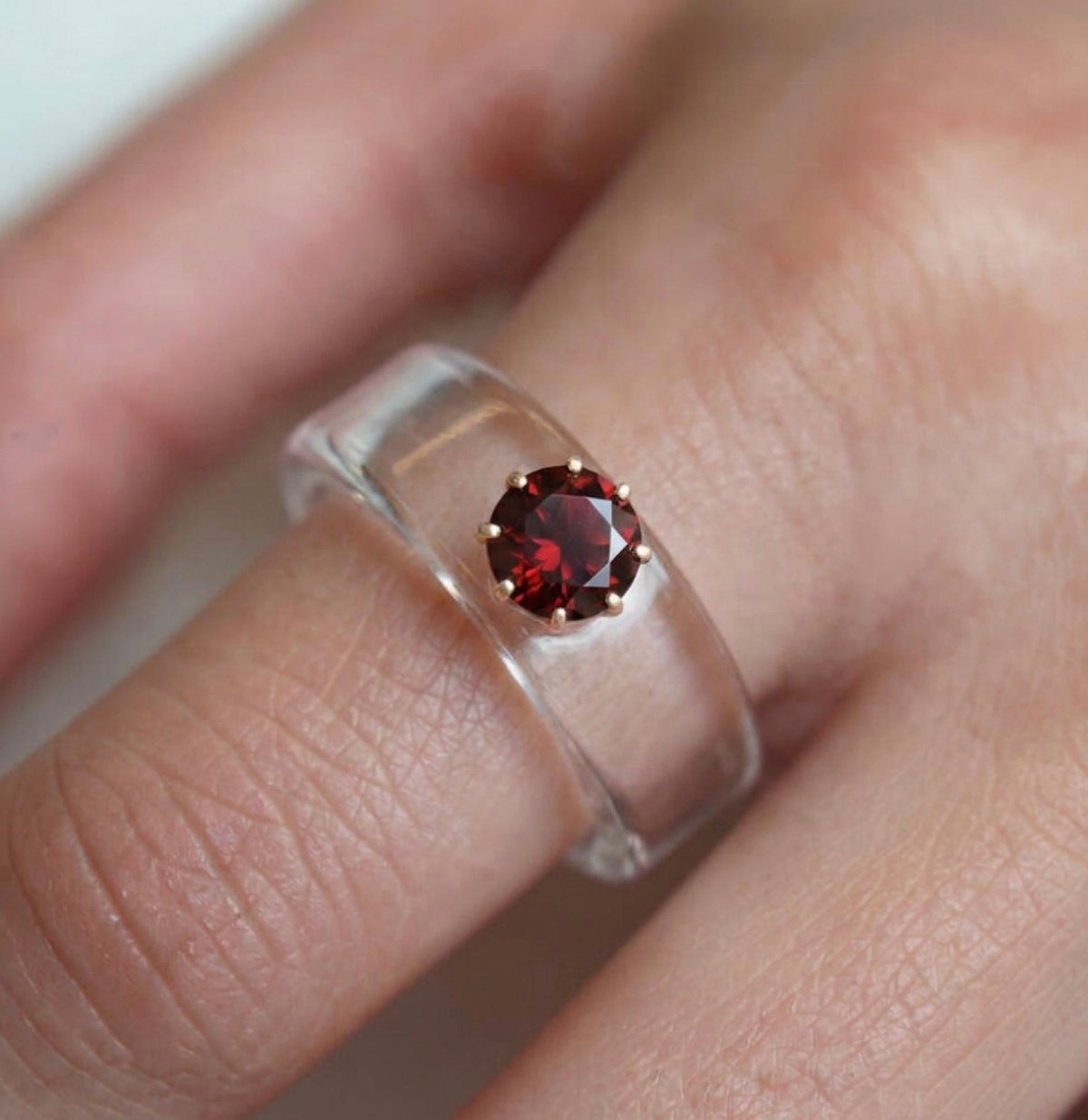 Anillo CG de granate y resina transparente, puesto en la mano