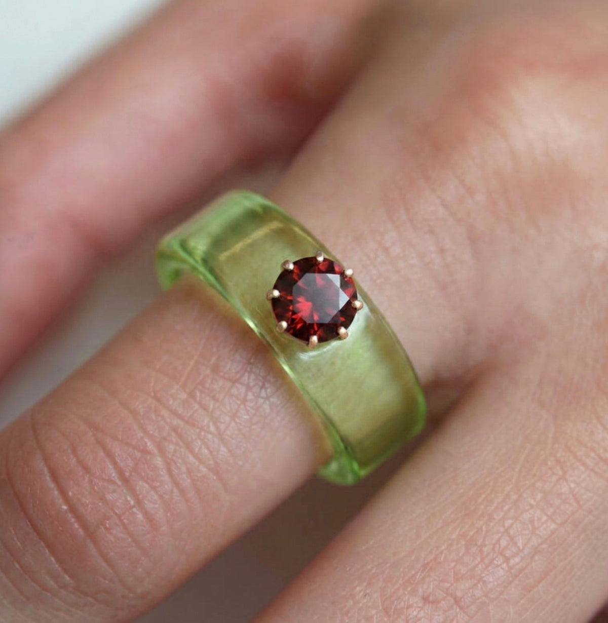 Anillo CG de granate y resina verde, puesto en la mano