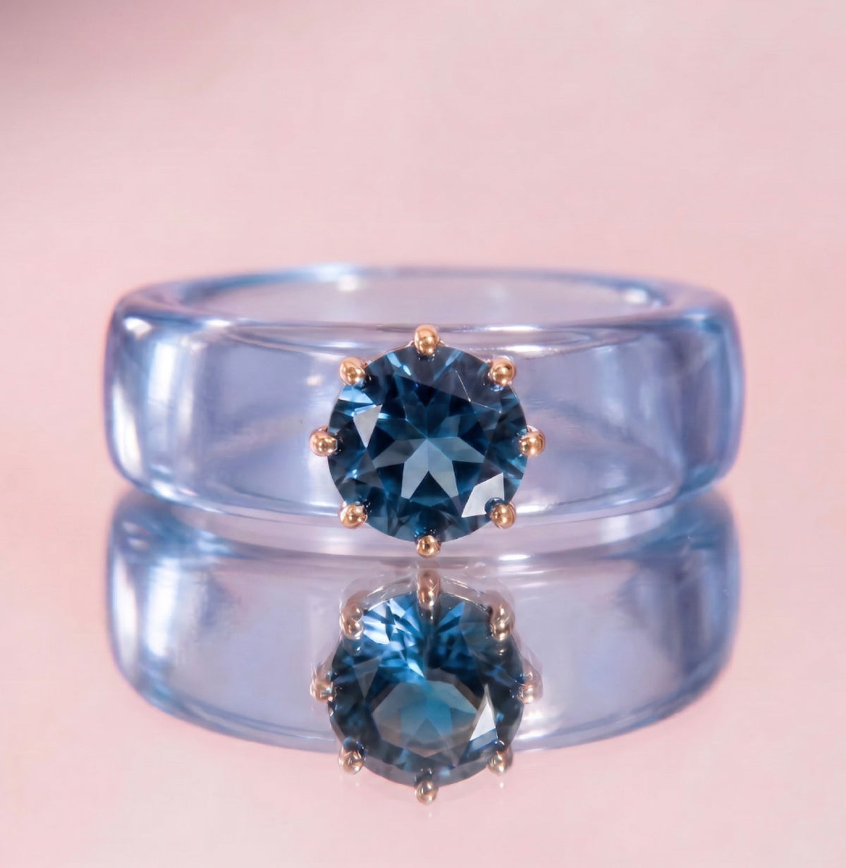 Anillo CG de topacio London Blue y resina celeste, puesto en la mano