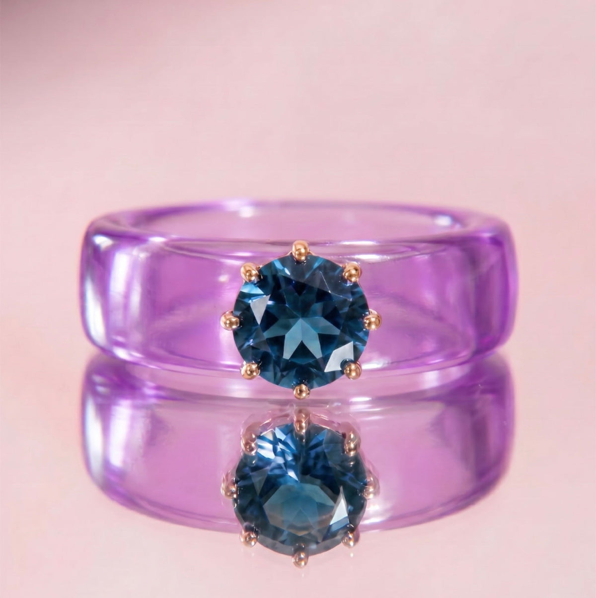 Anillo CG de topacio London Blue y resina morada, puesto en la mano