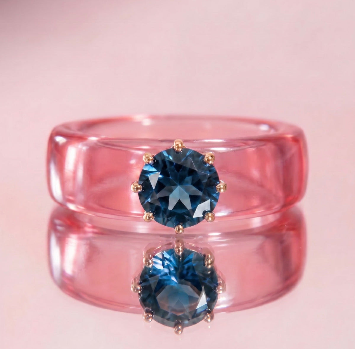Anillo CG de topacio London Blue y resina salmón, puesto en la mano
