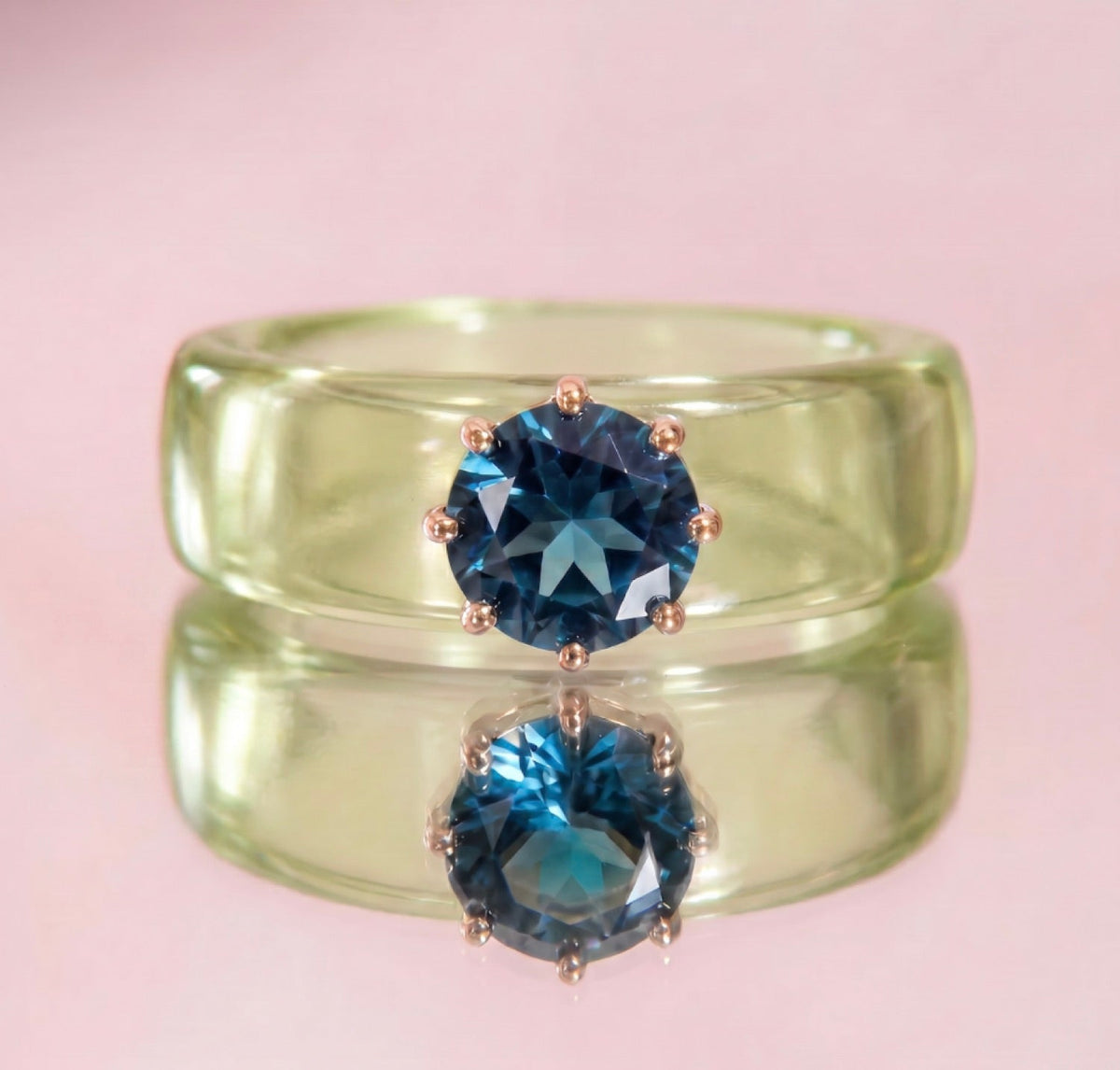Anillo CG de topacio London Blue y resina verde, puesto en la mano