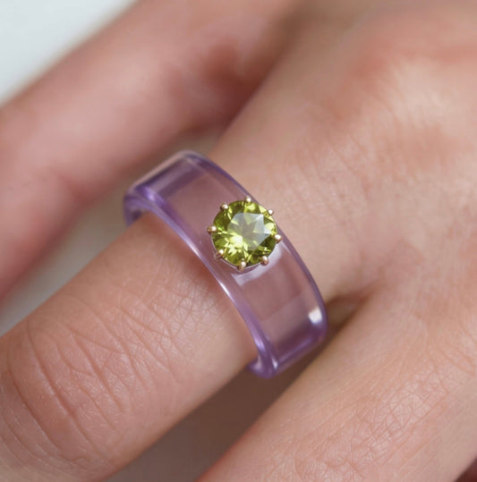 Anillo CG de peridoto y resina morada, puesto en la mano