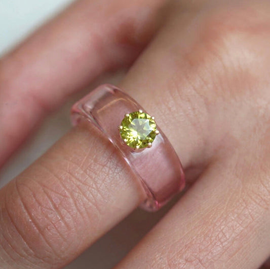 Anillo CG de peridoto y resina rosa, puesto en la mano