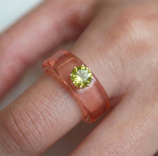 Anillo CG de peridoto y resina salmón, puesto en la mano