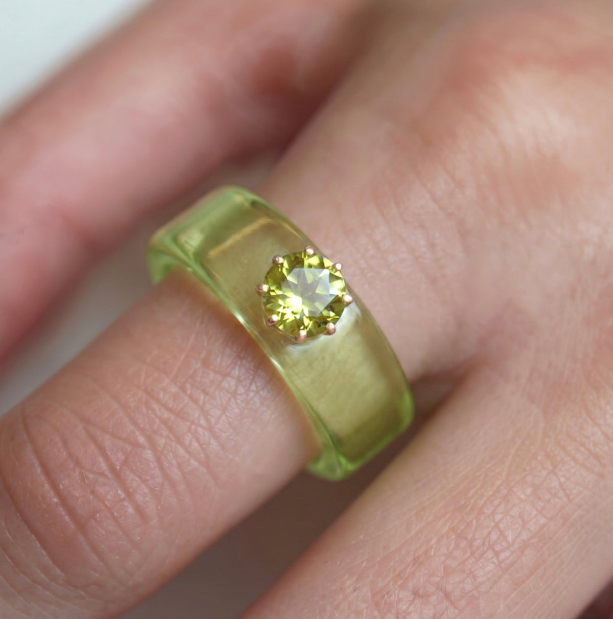 Anillo CG de peridoto y resina verde, puesto en la mano