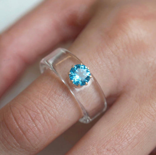 Anillo CG de topacio Swiss Blue y resina transparente, puesto en la mano