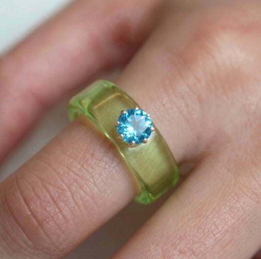 Anillo CG de topacio Swiss Blue y resina verde, puesto en la mano